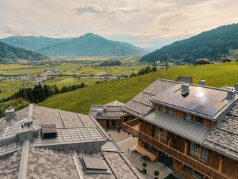 Blick über die Dächer des Hotel-Dorfs Zaglgut mit eigener Photovoltaikanlage inmitten der grünen Alpenlandschaft – ausgezeichnet mit dem österreichischen Umweltzeichen für nachhaltige Energielösungen wie PV und Pelletsheizung von bösch. | © Hotel & Chalets Zaglgut