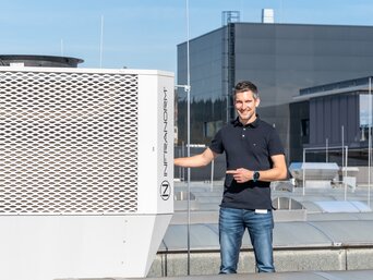 Mitarbeiter präsentiert die INFRANORM®-Kühleinheit des Sustainable Hall Conditioning Systems von bösch und INFRANORM® am Standort ENGEL Austria in Schwertberg