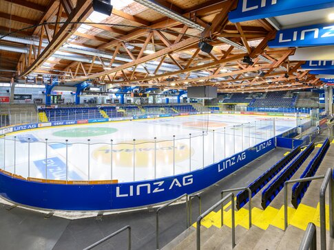 Eisarena Linz im Sommerbetrieb: klare Sicht dank trockener Hallenluft. | © LINZ AG/Fotokerschi Innenansicht der Linzer Eisarena mit freier Sicht auf Eisfläche, Videowürfel und Dachtragwerk. | © LINZ AG/Fotokerschi