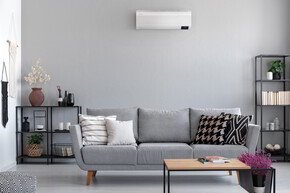 Wohnzimmer mit einem grauen Farbstil und Couch mit Split-Klimaanlage
